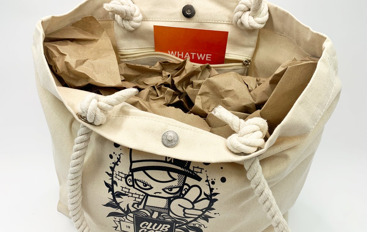 Interior view of an open canvas beach tote bag with snap closure and thick braided rope handles