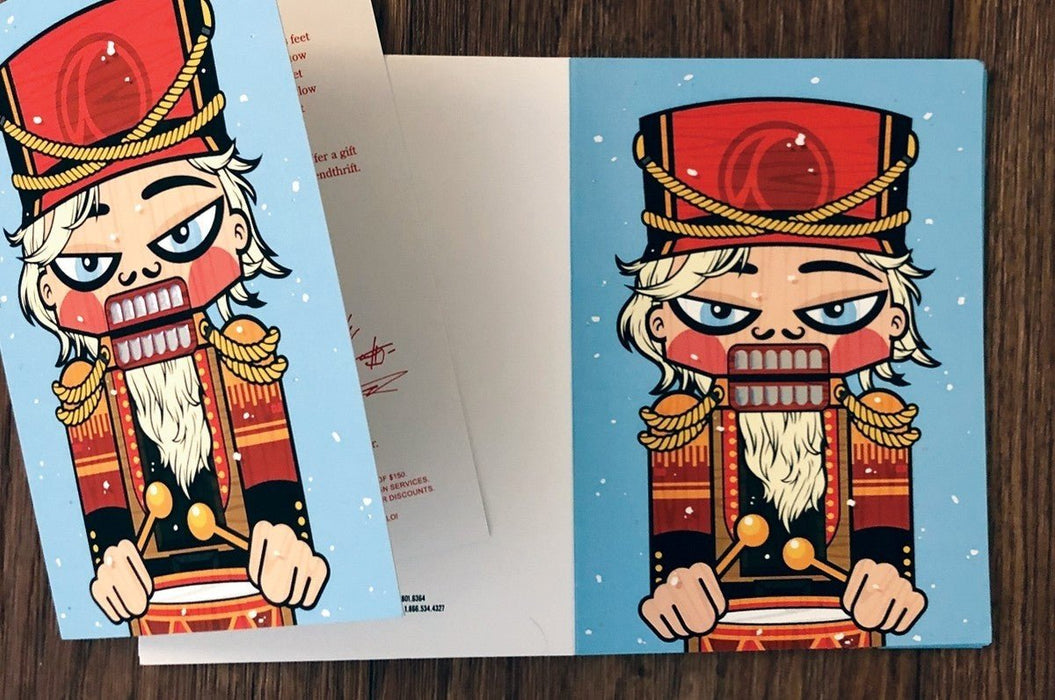 Open 7x5 folded holiday greeting card sample on 19pt suede stock showing printed interior and nutcracker cover with 3D raised iridescent foil accents