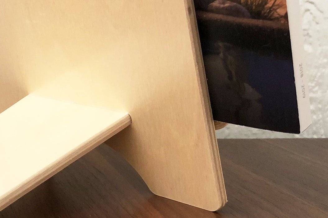 Close up on the structure of a birch plywood book display stand on a wooden table.