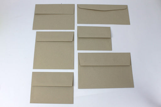Six different sizes of uncoated blank desert storm kraft envelopes on a white background.